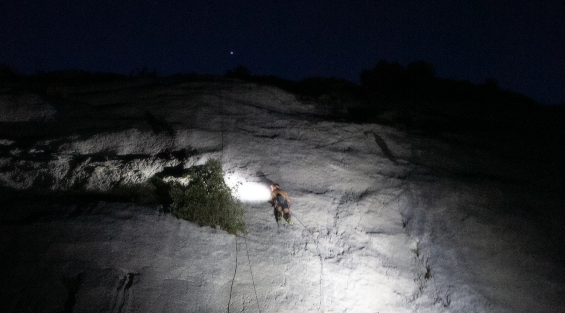 Climber in the night with headlamp in Sardinia Italy.
